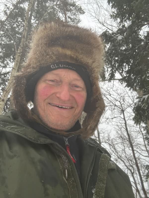 Harald med pälsmössa i den snöiga vinterskogen