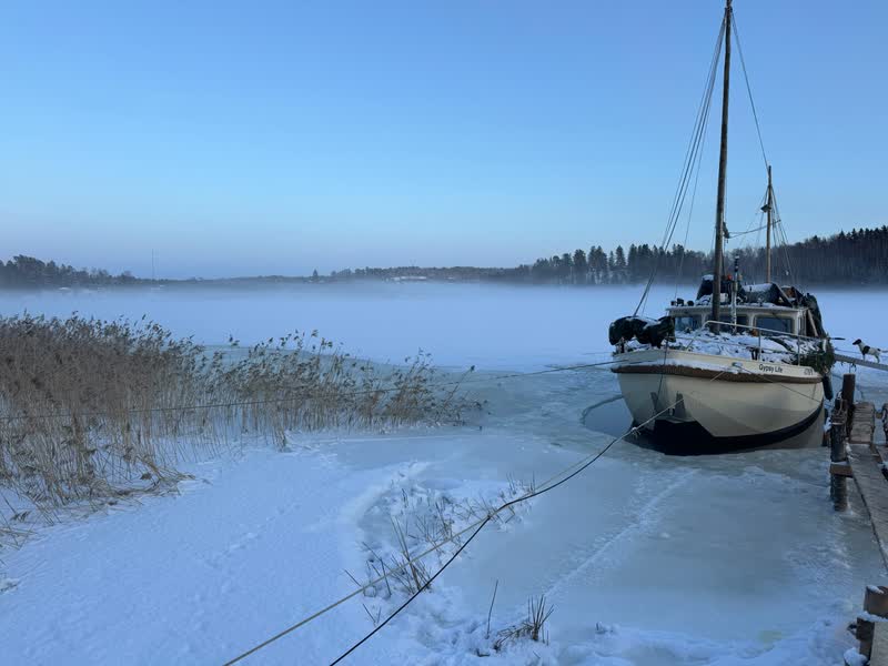 Gypsy Life ligger i den brytande isen medan dimma driver över viken