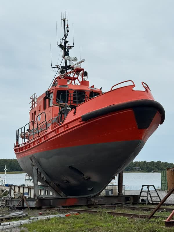 The red and black pilot boat standing on the yard’s slipway cradle