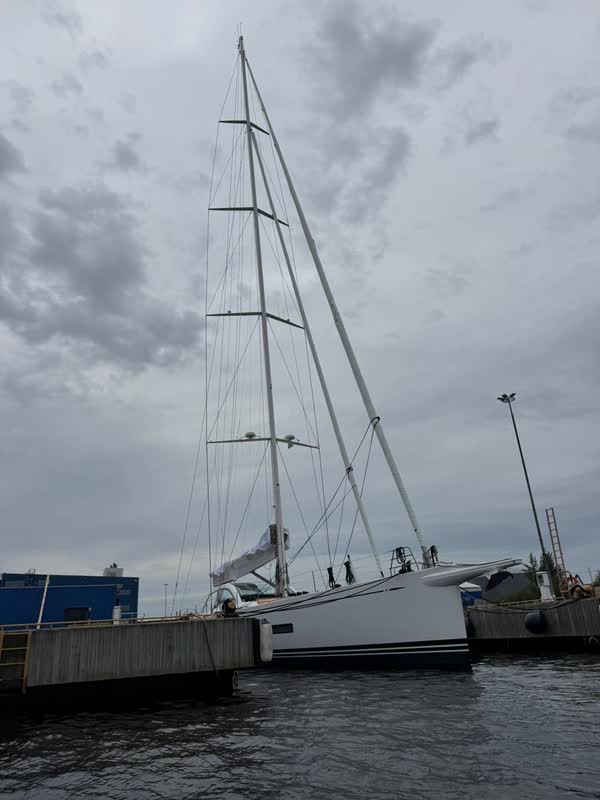 Tom Cruise’s Swan 108 from the side: a slender white hull with a dark cove line and a tall carbon mast at the Nautor Swan yard in Finland